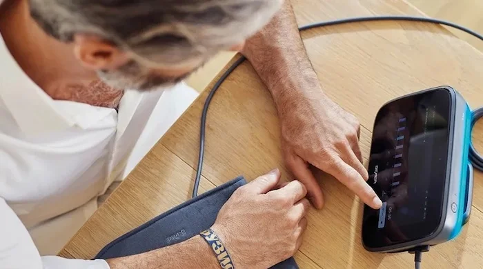 Eine Person bedient ein BEMER evo Gerät per Touchdisplay auf einem Tisch.