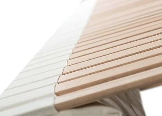 Detailaufnahme der Holzlamellen einer Ergofit Matratze zur ergonomischen Körperstützung.