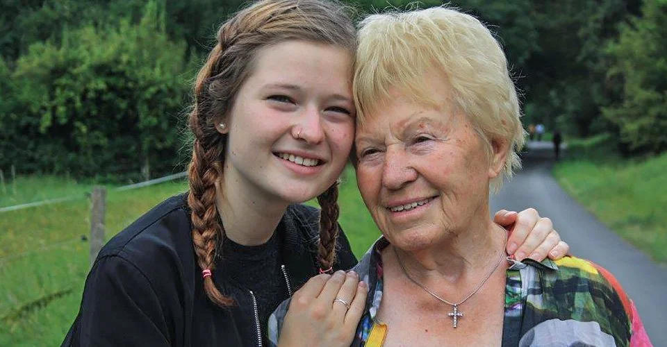 Ältere Dame umarmt von Teenager