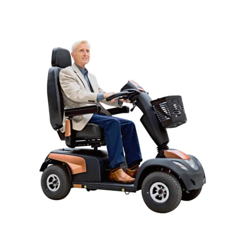 Man sitzt in Elektromobil Comet Pro mit komfortablem Sitz, Armlehnen und Frontkorb.